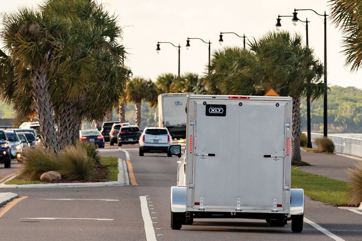 Rear view of 6-wide XLT Pro gray trailer going down road