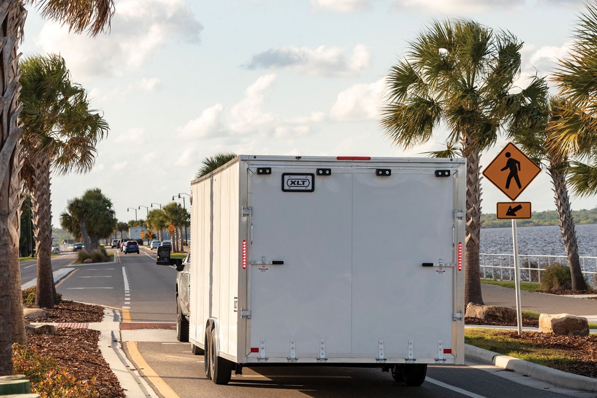 Rear view of white XLT Pro Car Hauler driving down highway