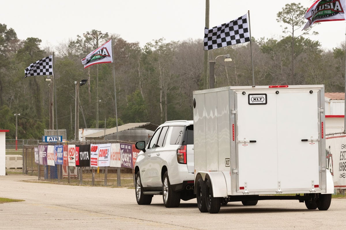 White SUV towing 7 Wide XLT Pro down race track road