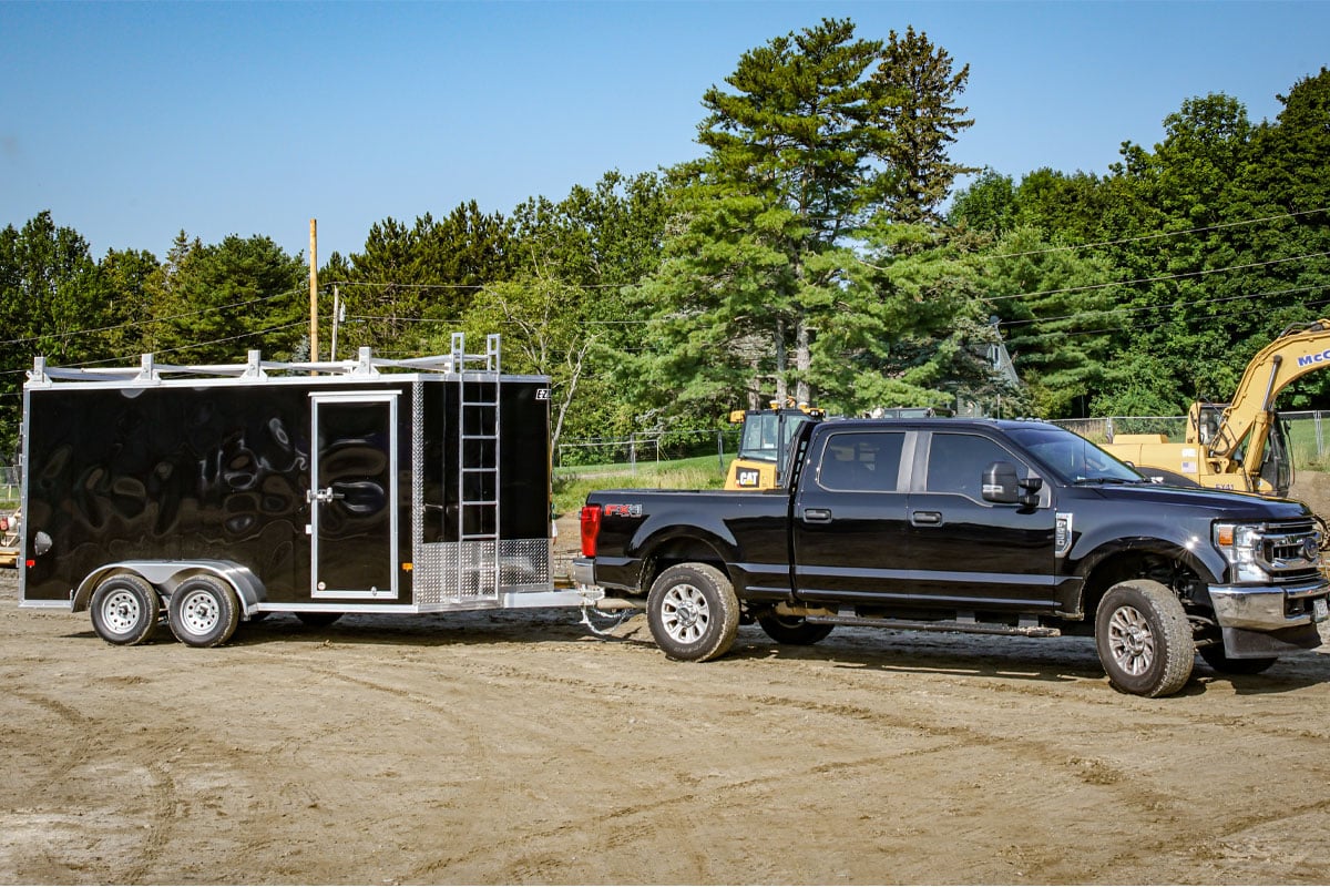 black-truck-carrying-black-trailer